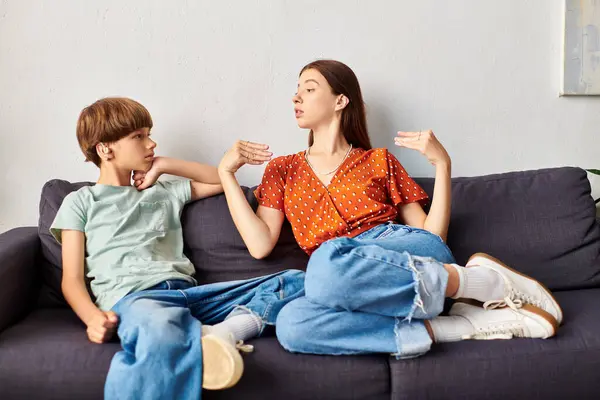 A mother engages in heartfelt conversation with her son on the couch. — Stock Photo