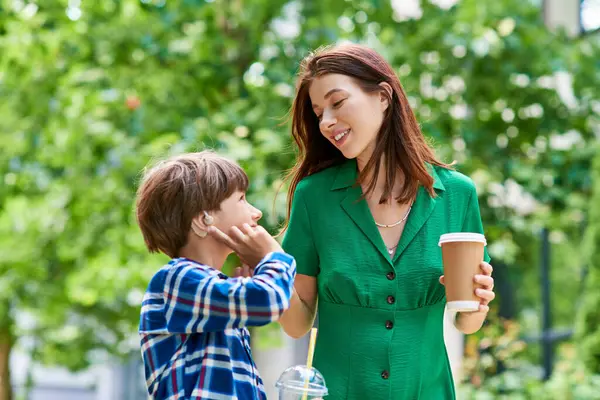 A mother and her hearing impaired son share laughter and connection outdoors. — Stock Photo