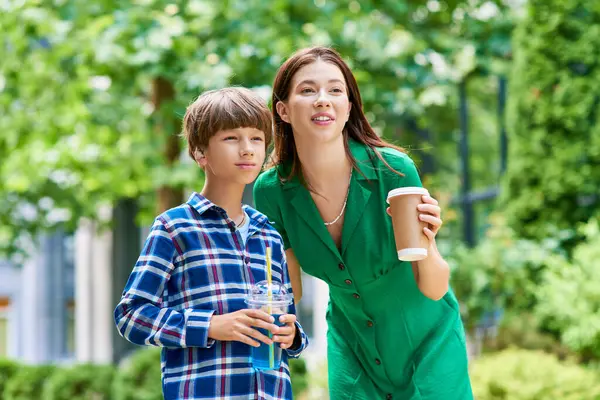 A mother shares a joyful moment with her son in a vibrant green park. — Stock Photo