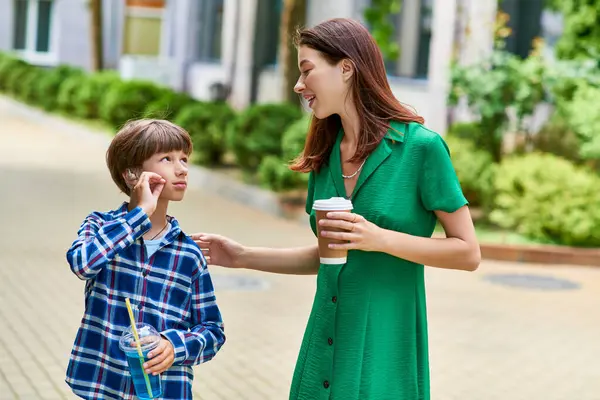 Mother and son share a warm moment in the park, enjoying drinks and conversation. — Stock Photo
