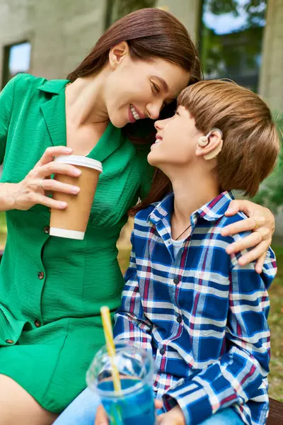 Eine Mutter und ihr schwerhöriger Sohn verbringen einen warmen Moment im Park. — Stockfoto