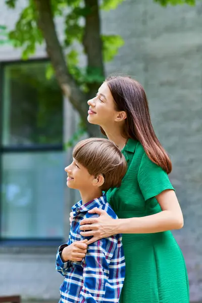 A mother joyfully embraces her hearing impaired son in a park. — Stock Photo