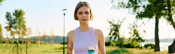 Eine junge Frau steht anmutig in einem sonnenbeschienenen Park und umarmt die Ruhe der Natur. — Stockfoto