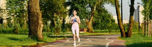 Jogging along a peaceful path surrounded by trees and sunlight. — Stock Photo