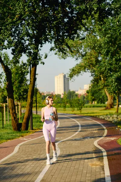 Una giovane donna gode di una passeggiata rinfrescante in un parco soleggiato circondato da alberi lussureggianti. — Foto stock