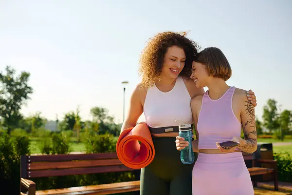 Duas mulheres compartilham riso e conexão enquanto relaxam ao ar livre. — Fotografia de Stock