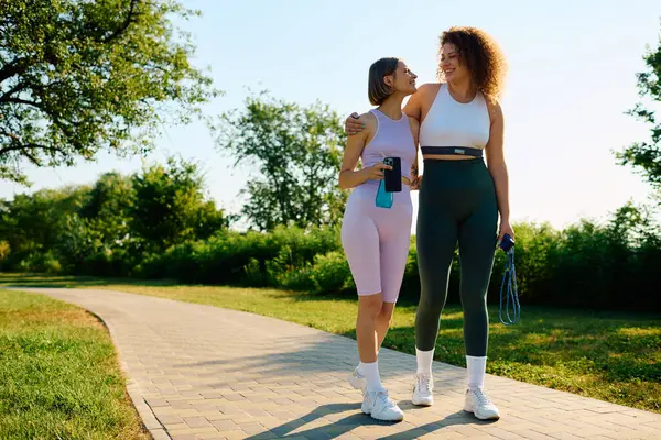 Two women share smiles and laughter during their outdoor workout. — Stock Photo