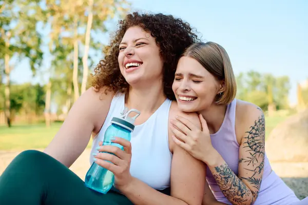 Duas mulheres compartilham riso e amor em um dia brilhante na natureza. — Fotografia de Stock