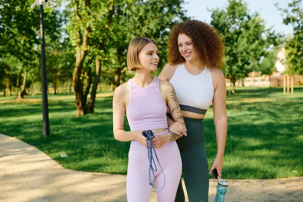 A loving couple walks hand in hand, sharing smiles in a vibrant park. — Stock Photo