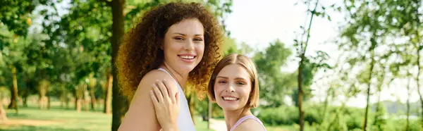 Two women share laughter and connection in a vibrant park setting. — Stock Photo
