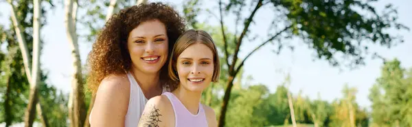 Two happy women connect and share laughter in a vibrant park setting. — Stock Photo