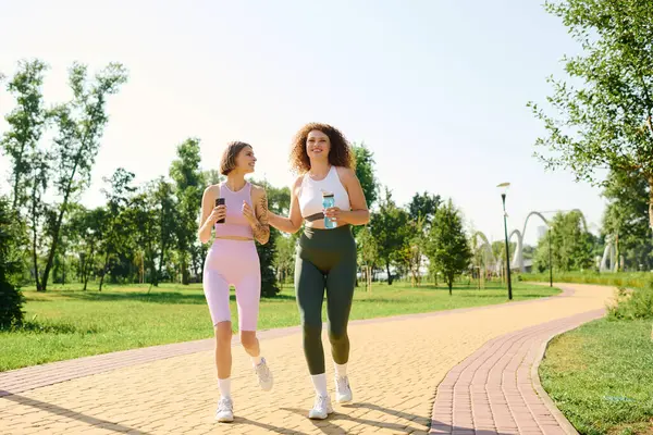 Happy couple jogging in the park, soaking up the sun and sharing joyful moments. — Stock Photo