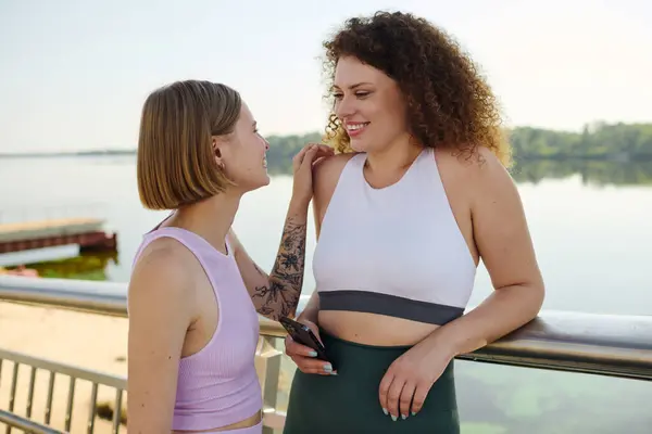 Zwei Frauen teilen Lachen und Freude beim Entspannen am Wasser. — Stockfoto