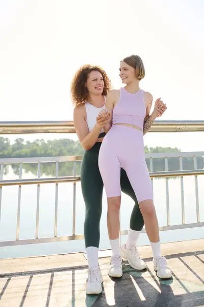Two women share laughter and love while embracing by the lakeside. — Stock Photo