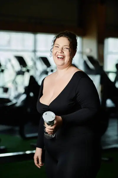 Una giovane donna sorride brillantemente mentre si allena nel suo activewear, celebrando la positività del corpo e la forza. — Foto stock