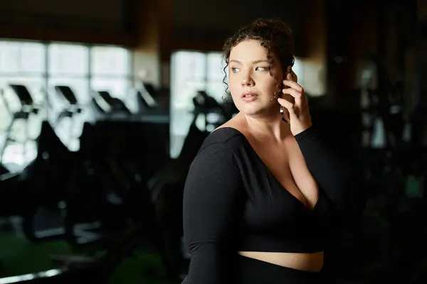 Женщина plus-size набирает силу, работая в стильной активной одежде. — стоковое фото