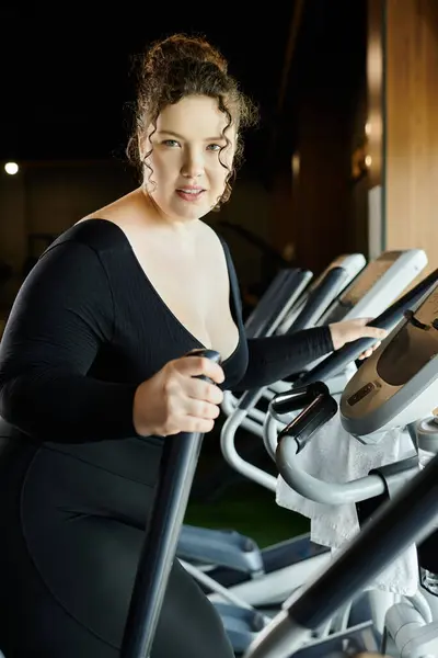 A confident young woman exercises on a gym machine, promoting body positivity and a healthy lifestyle. — Stock Photo
