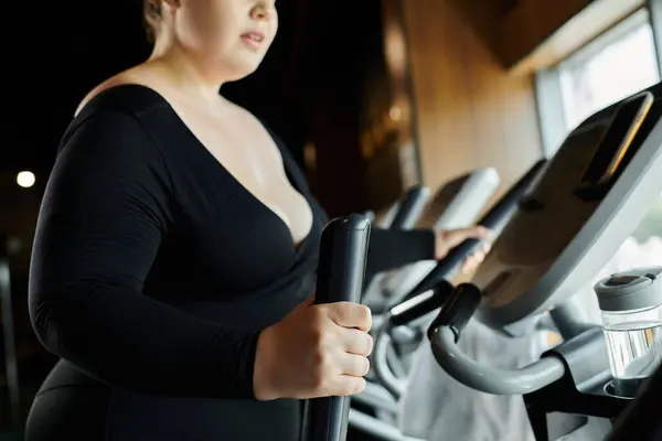 Женщина plus-size занимается в тренажерном зале, воплощая в себе позитив и решимость. — стоковое фото