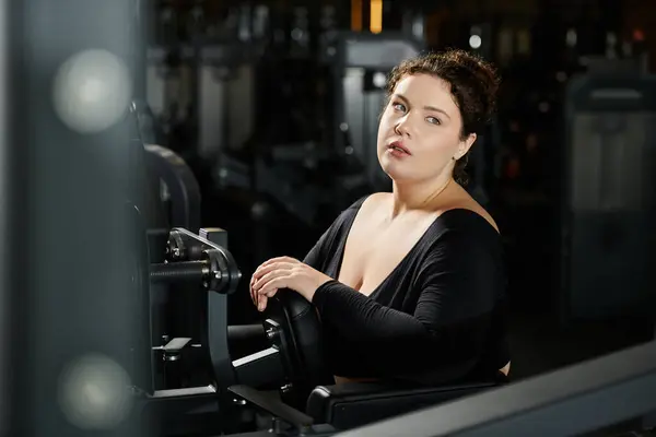 Una donna plus-size abbraccia la sua forza mentre lavora in palestra. — Foto stock