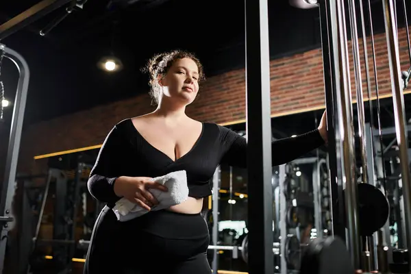 Uma jovem mulher limpa a testa com uma toalha, incorporando força e confiança durante o exercício.. — Fotografia de Stock