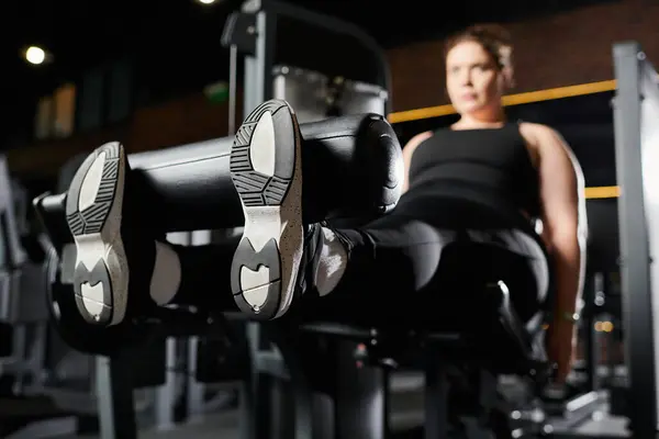 A plus-size woman confidently engages in a workout at the gym, embracing body positivity. — Stock Photo