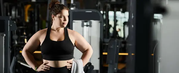 Una giovane donna plus-size in activewear si potenzia durante una sessione di allenamento in palestra. — Foto stock