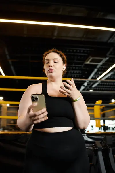 A young woman in active wear confidently works out while tracking her progress at the gym. — Stock Photo