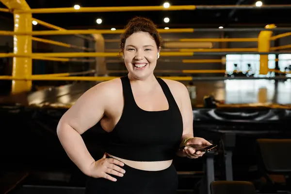 A plus-size woman smiles confidently while exercising in active wear at the gym. — Stock Photo