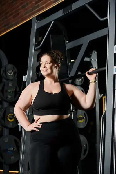 A young woman embraces her strength while working out and uplifting body positivity in a gym. — Stock Photo