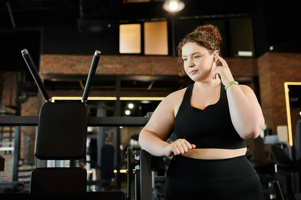 Une jeune femme de plus de taille s'engage dans sa routine d'entraînement, embrassant la positivité du corps au gymnase. — Photo de stock