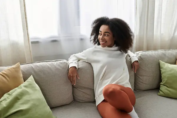 A young woman relaxes in her cozy attire, embracing comfort while enjoying her home environment. — Stock Photo