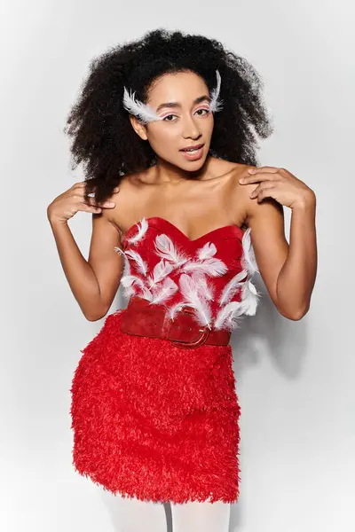 A young woman showcases her style in a red feathered outfit, exuding confidence and grace. — Stock Photo