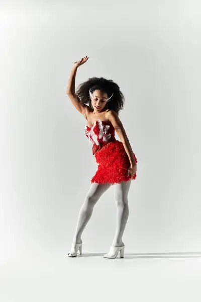 A stylish young woman showcases her flair in a bold red outfit with feathers, exuding confidence. — Stock Photo