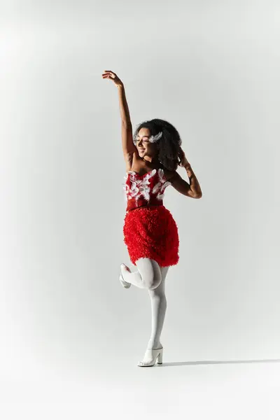 The young woman showcases her style and confidence in a striking red feathered ensemble. — Stock Photo