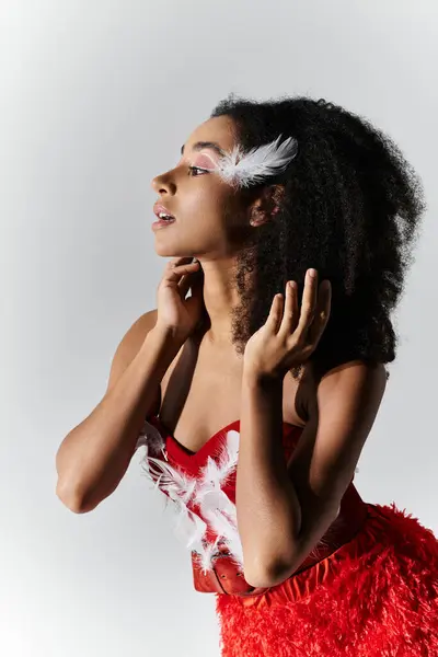 A stylish young woman poses gracefully in a vibrant red ensemble, exuding confidence and elegance. — Stock Photo