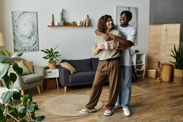 A happy couple embraces warmly at home, sharing love and cups of coffee in a cozy setting. — Stock Photo