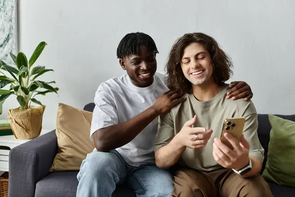 A loving couple shares laughter while looking at their phone in their comfortable home. — Stock Photo