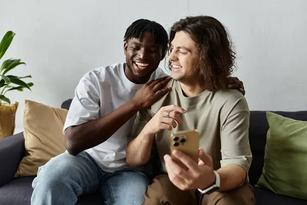 Due partner felici condividono un momento sentito, sorridendo e collegandosi per telefono nella loro accogliente casa. — Foto stock