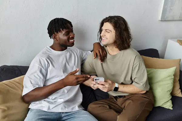 Two partners share laughter and warmth while relaxing together on their couch. — Stock Photo