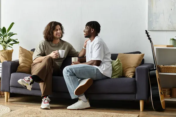 Two partners share a warm conversation with cups in hand, surrounded by their cozy home. — Stock Photo