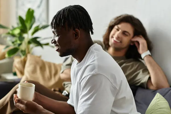 Two partners enjoy a relaxing moment together, exchanging smiles and laughter in their cozy space. — Stock Photo