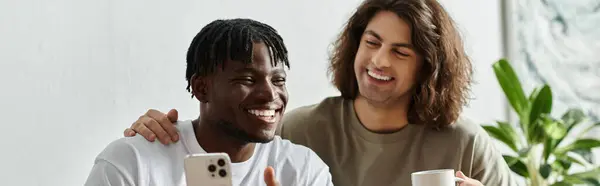 Two partners enjoy a light hearted moment at home, sharing laughter over coffee and a phone. — Stock Photo