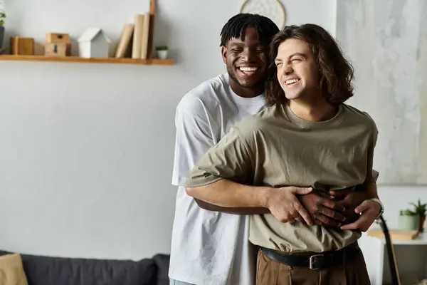 A loving gay couple embraces each other warmly while enjoying their time together at home. — Stock Photo