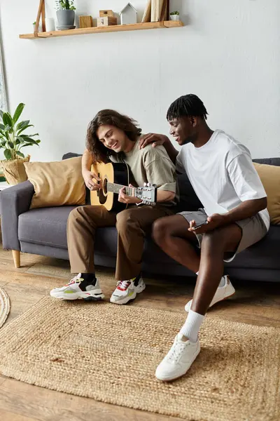 Two partners share a cozy moment, strumming a guitar and enjoying each other. — Stock Photo