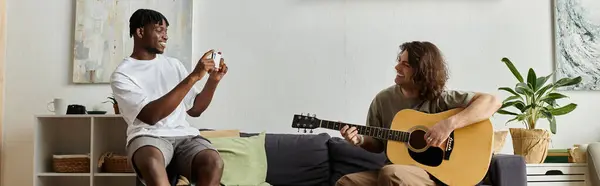 Two men enjoy a cozy evening together, filled with laughter and music in their living room. — Stock Photo