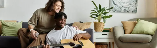 Two partners share a tender moment while playing music at home, surrounded by warmth and comfort. — Stock Photo