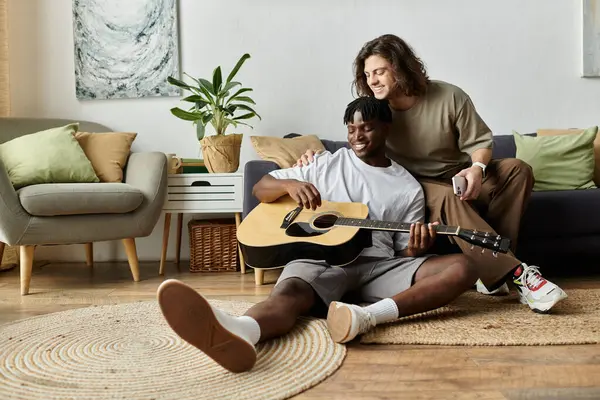 A couple shares a heartwarming moment while playing guitar in their inviting living space. — Stock Photo