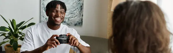 A joyful couple shares laughs while taking pictures in their comfortable living room. — Stock Photo