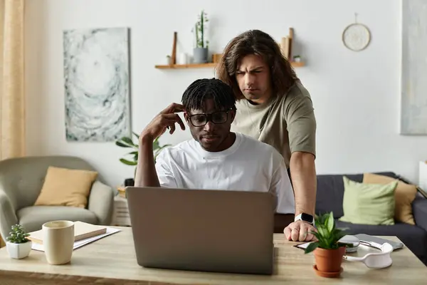Due uomini godono la loro atmosfera accogliente casa come collaborano su un computer portatile. — Foto stock