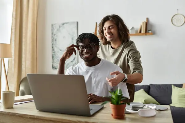 A joyful couple shares a warm moment, collaborating on a laptop in their bright living space. — Stock Photo